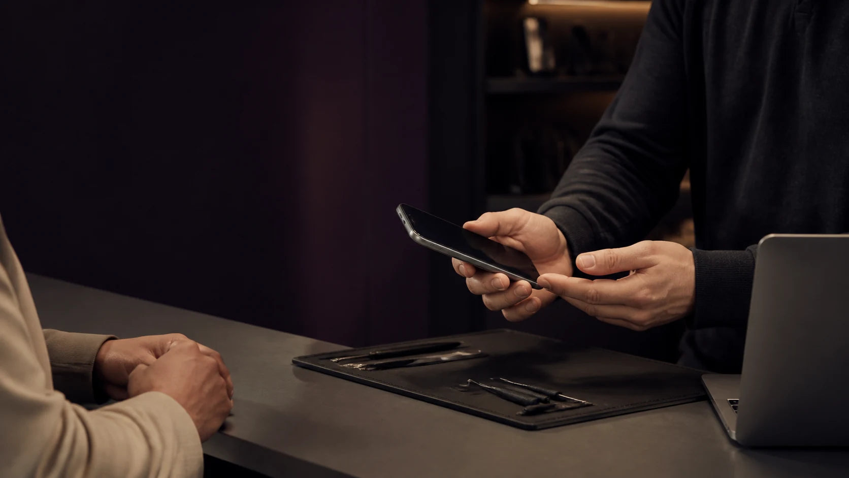 A MoboPlus technology specialist carefully helping a customer with a device